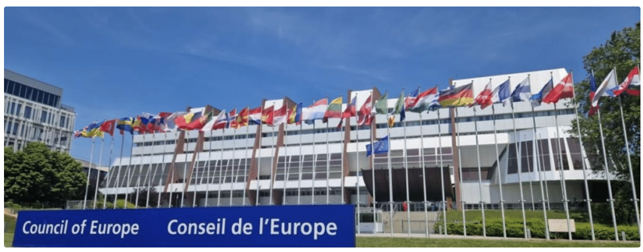 A building with many flags on the top of it